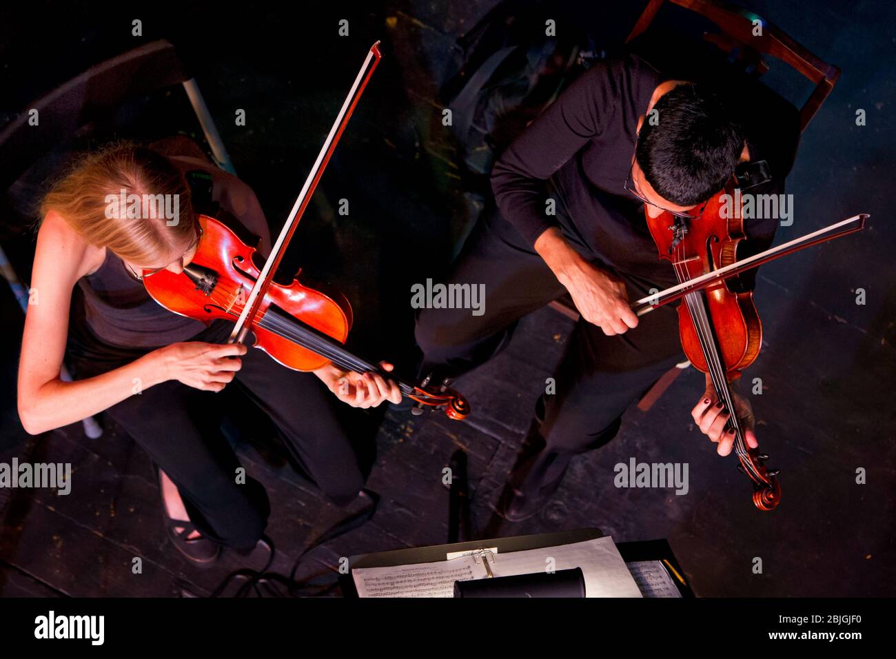 Ansicht von oben auf die Geigenspieler (Modell veröffentlicht), die im klassischen Orchester auftreten. Stockfoto