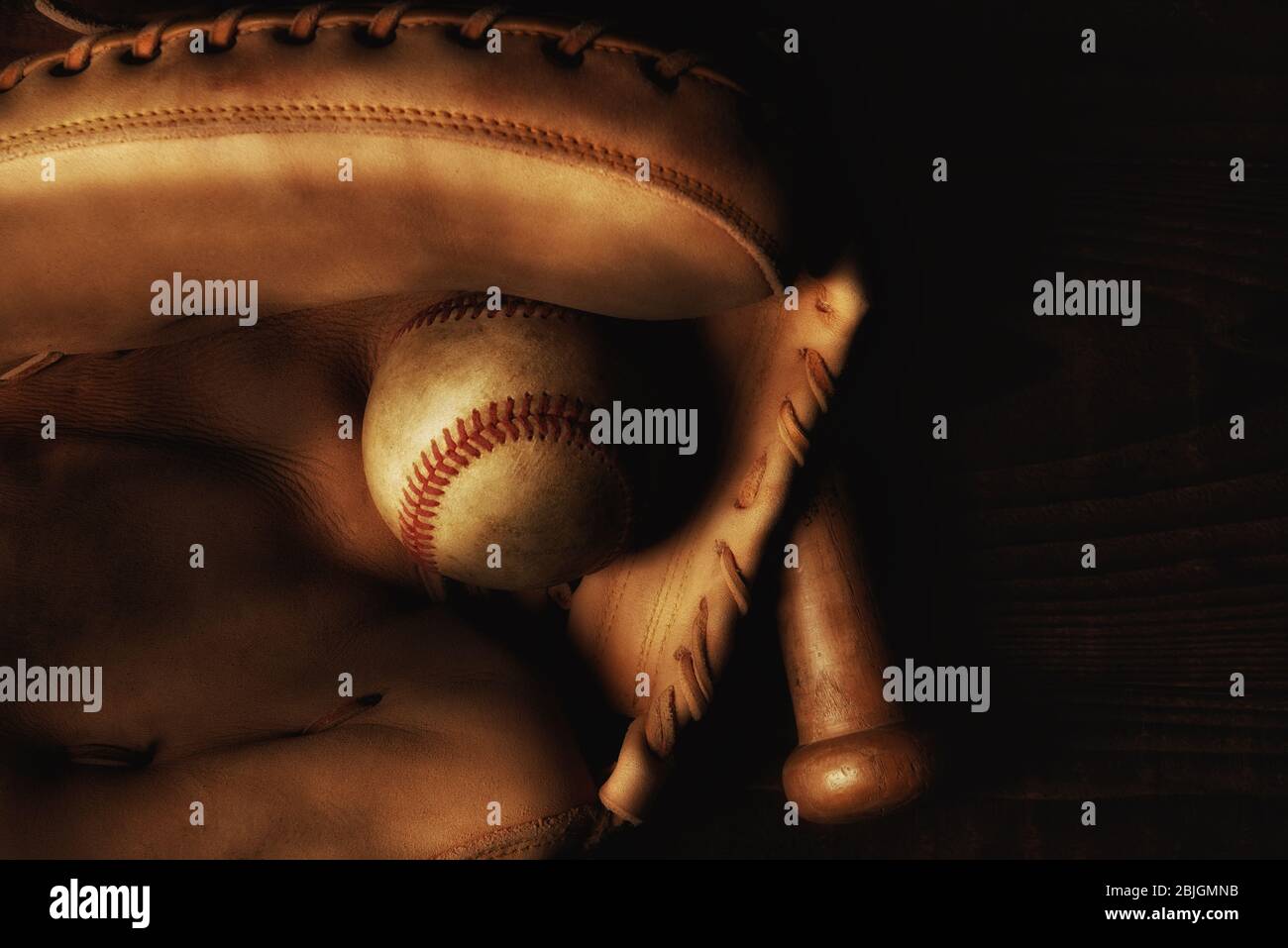 Nahaufnahme eines Catchers Mitt mit einem gebrauchten Baseball und Fledermaus. Stockfoto