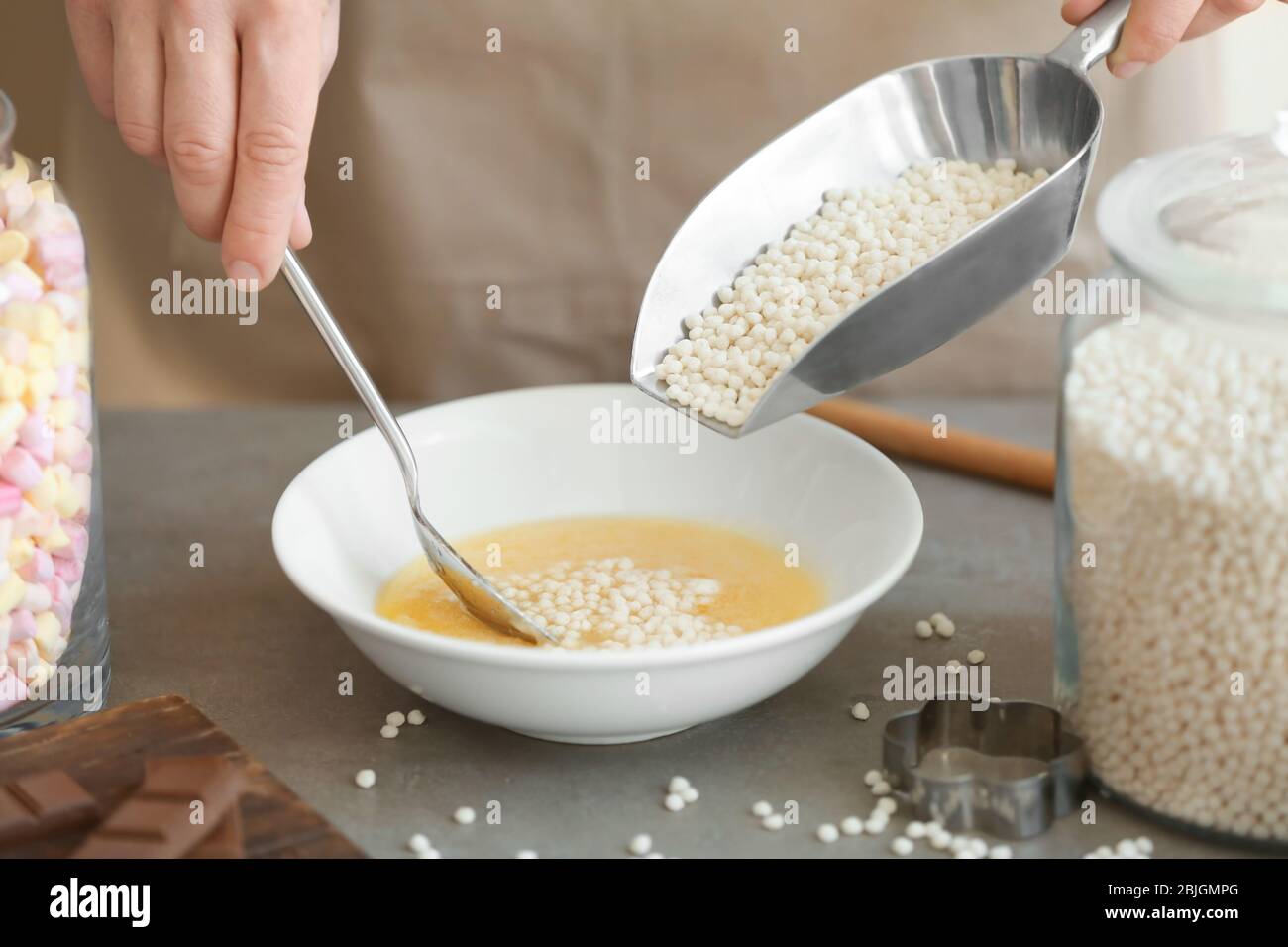 Frau Hinzufügen knusprige Reisbällchen in Schüssel auf dem Tisch Stockfoto