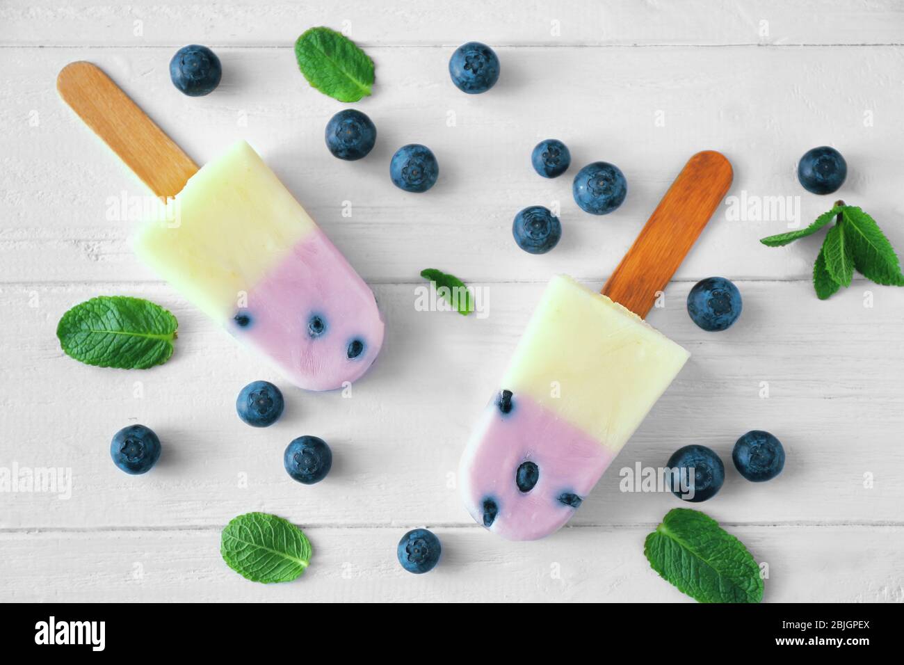 Hausgemachte Eiswürfel mit Heidelbeeren auf Holzhintergrund Stockfoto