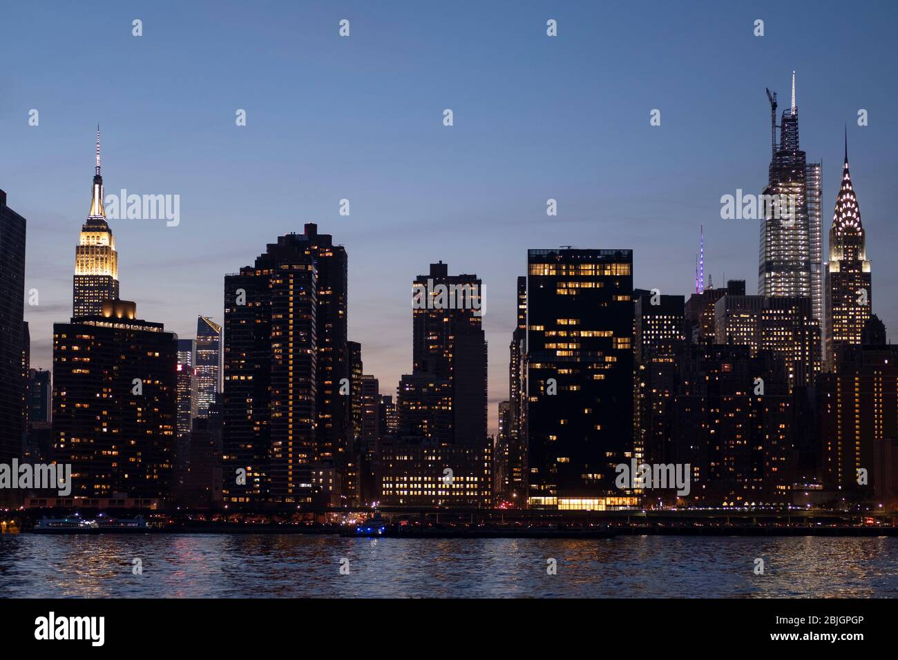 Abendansicht der Skyline von Manhattan mit Empire State, einem Vanderbilt und Chrysler-Gebäuden vom East River in New York City Stockfoto