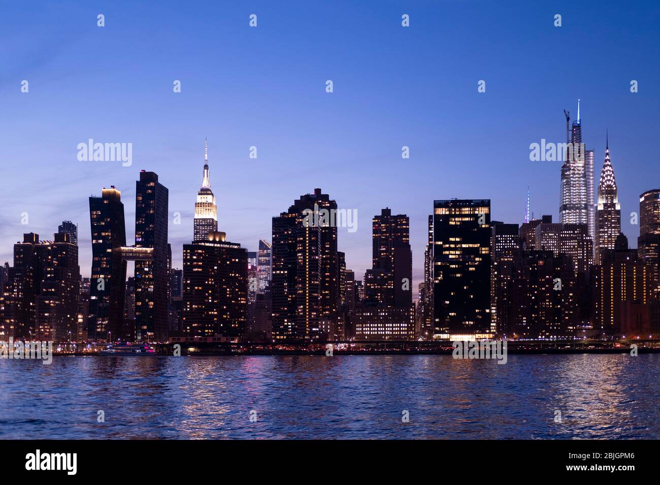 Abendansicht der Skyline von Manhattan mit Empire State, einem Vanderbilt und Chrysler-Gebäuden vom East River in New York City Stockfoto