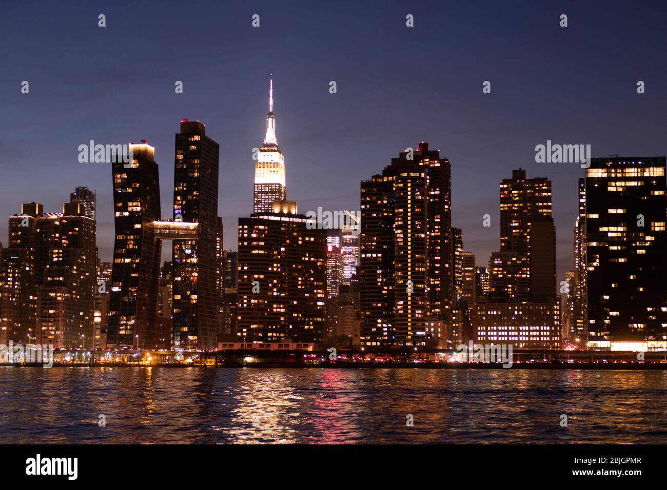 Blick in die Abenddämmerung auf die Skyline von Manhattan mit dem berühmten Empire State Building vom East River in New York City aus gesehen Stockfoto