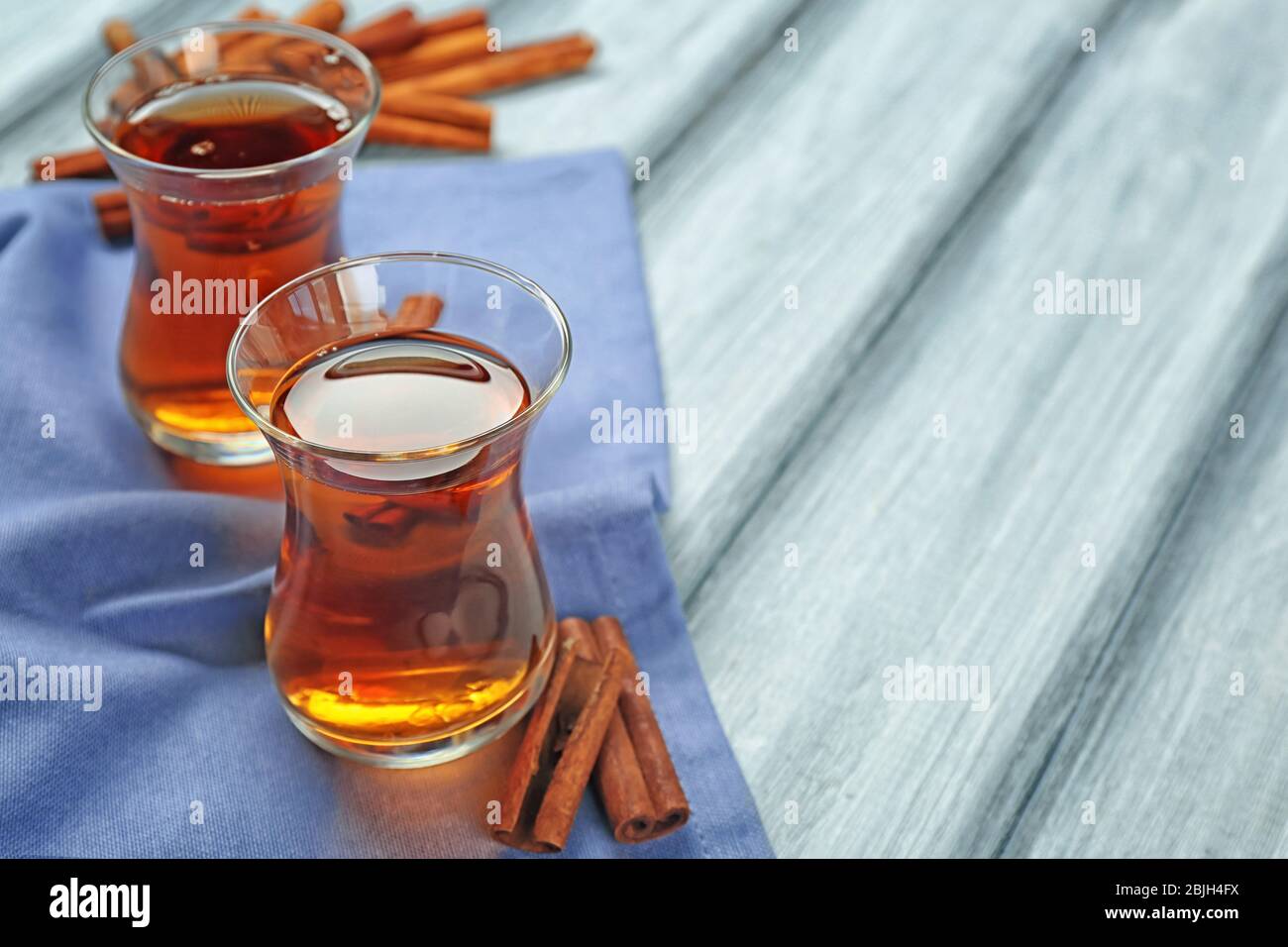 Zwei Glasbecher mit aromatischem heißen Zimttee auf Holztisch Stockfoto
