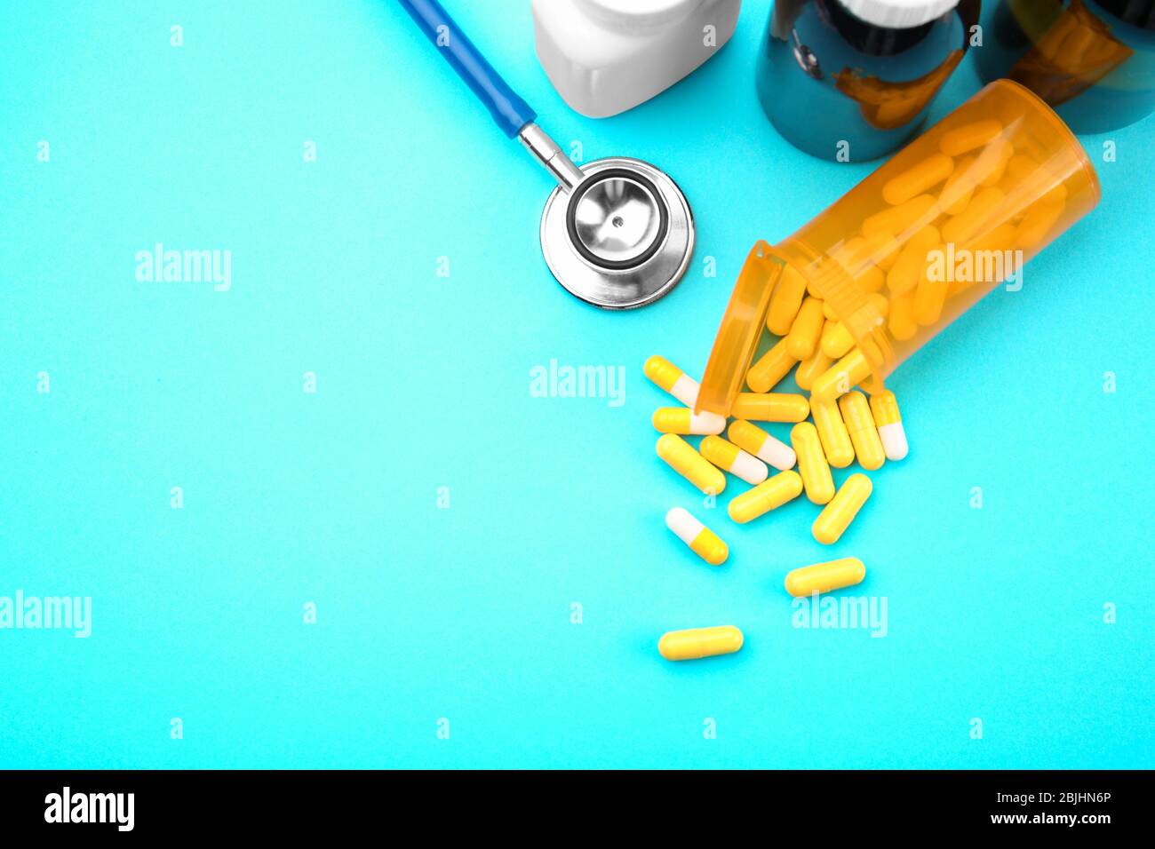 Konzept der Gesundheitsfürsorge. Komposition mit Pillen und Stethoskop auf blauem Hintergrund Stockfoto
