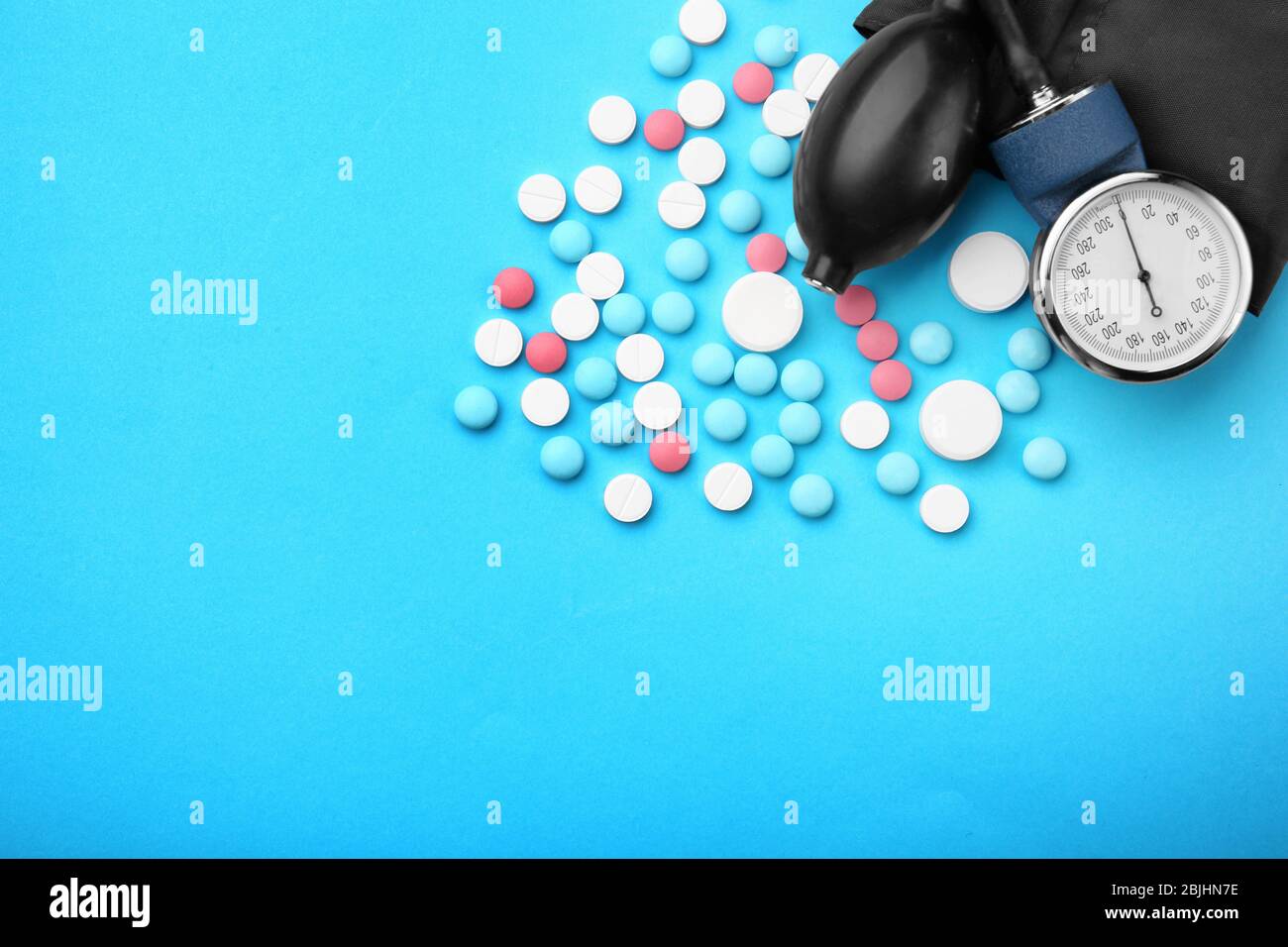 Konzept der Gesundheitsfürsorge. Zusammensetzung mit Pillen und Sphingometer auf blauem Hintergrund Stockfoto