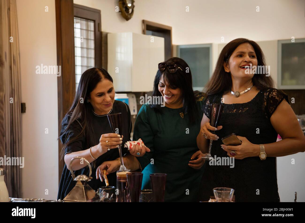 Eine Gruppe von Frauen, die sich auf einer Kitty Party für einen Toast vorbereiten. Stockfoto