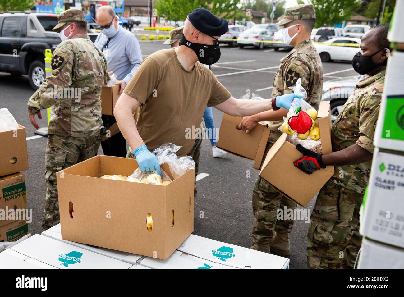 Der technische Sergeant Nathan Prescott (C) der Washington National Guard arbeitet mit anderen Soldaten zusammen, um Kisten mit freiem Essen an die Bewohner unter zu verteilen Stockfoto