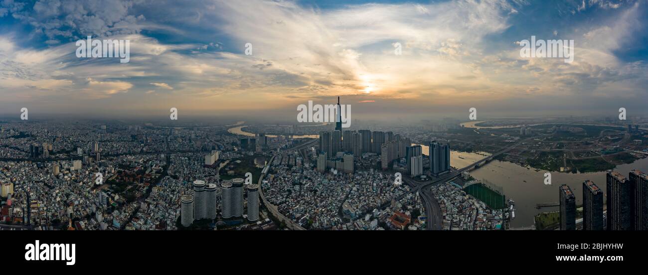 Sonnenaufgang weite Panorama-Drohne Aufnahme von Ho Chi Minh City Stadtlandschaft mit hohen Türmen und Blick auf Saigon Fluss, Binh Thanh District und Thu Thiem Stockfoto