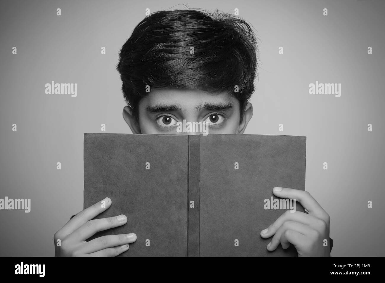 Schwarz-Weiß-Porträt eines Jungen, der ein Buch in der Hand hält. (Kinder) Stockfoto