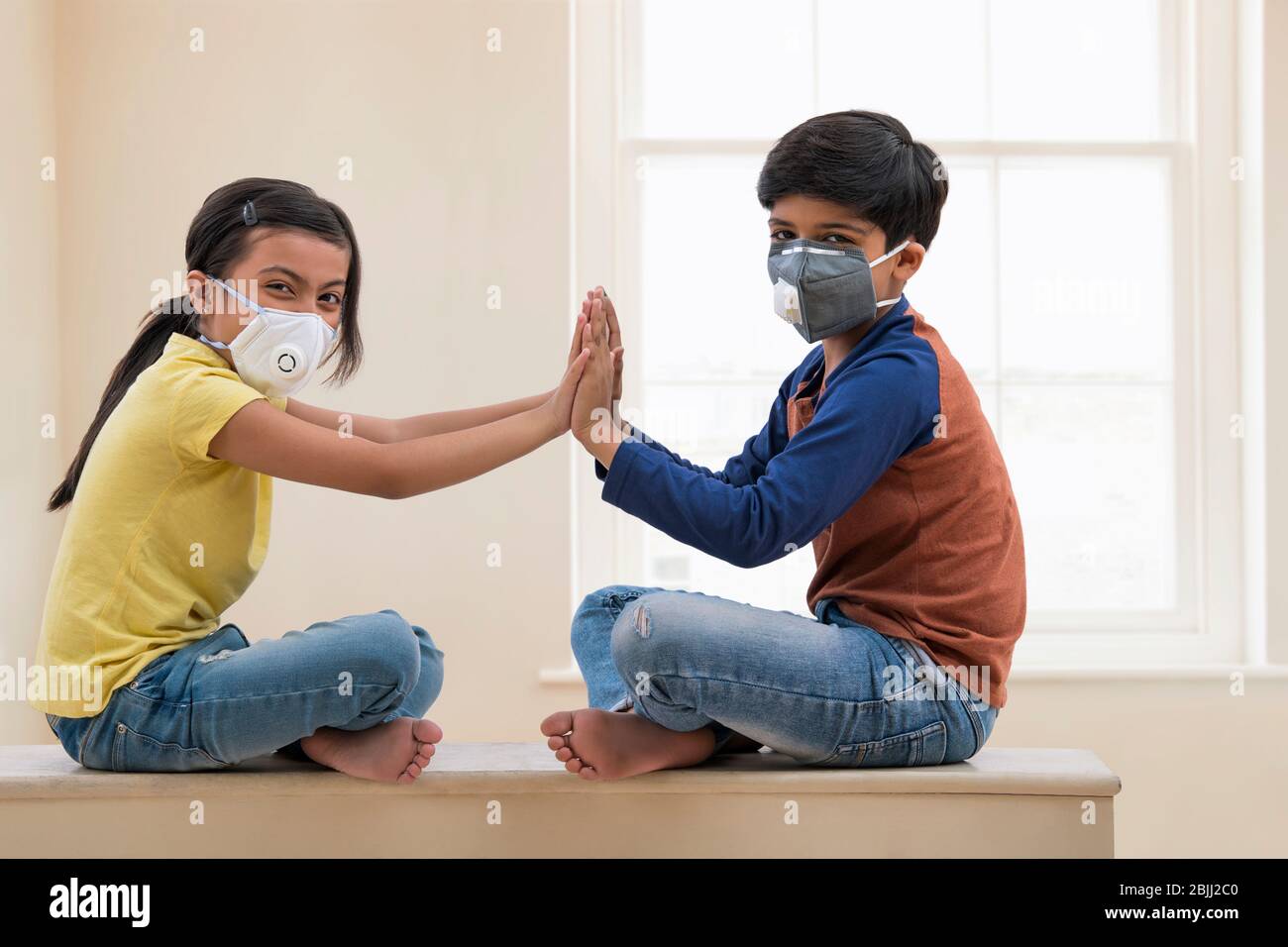 Bruder und Schwester spielen zu Hause mit Verschmutzungsmasken. (Kinder) Stockfoto