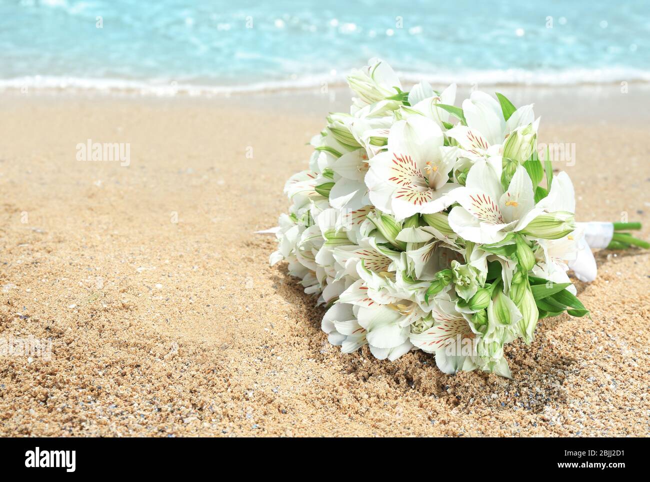 Schöner Strauß auf Sand. Hochzeitskonzept am Strand Stockfoto