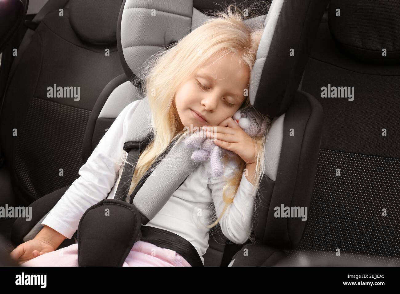 Blonde Mädchen schlafen in Kindersitz mit kleinen Spielzeug Stockfotografie  - Alamy