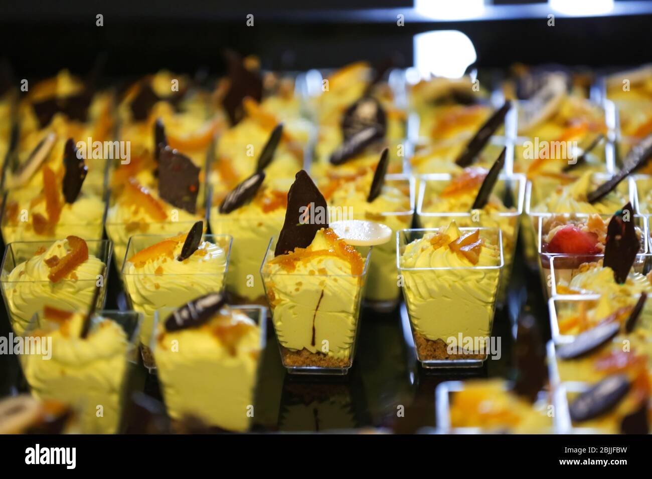 Viele Gläser mit gelben Mini-Desserts Nahaufnahme Stockfoto