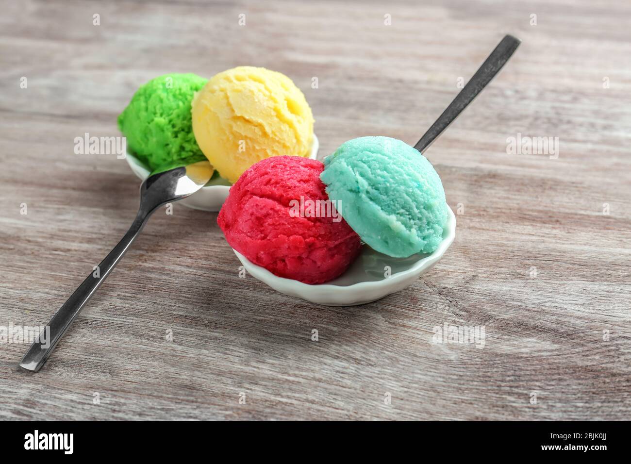 Komposition mit bunten Kugeln Eis und Löffel auf Holzhintergrund Stockfoto