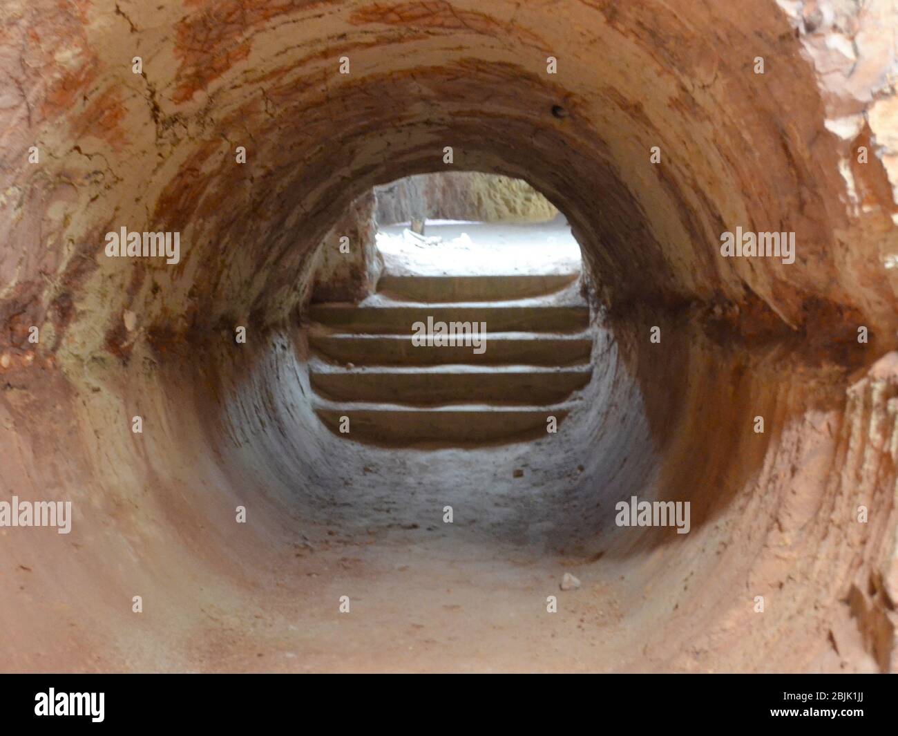 Sandsteinfelsen-Tunnel mit Stufen, die draußen zum Tageslicht führen in einer alten Opalmine in Coober Pedy in Australien Stockfoto