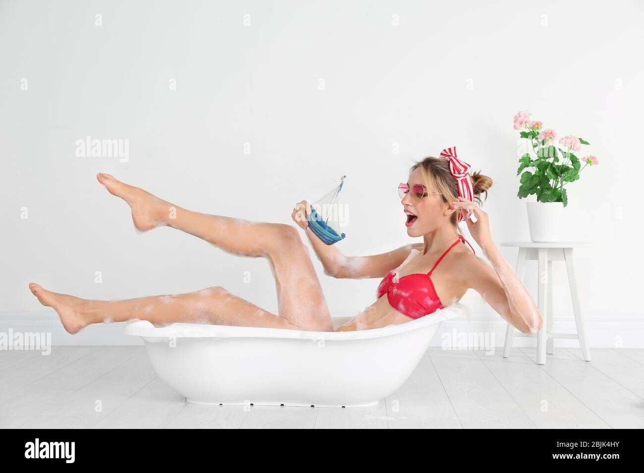 Lustige Junge Frau Spielt Mit Spielzeug Schiff In Der Badewanne In Der Nahe Von Weissen Wand Stockfotografie Alamy