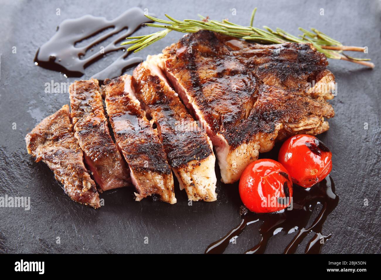 Leckeres gegrilltes Steak mit Rosmarin auf Schieferplatte Stockfoto