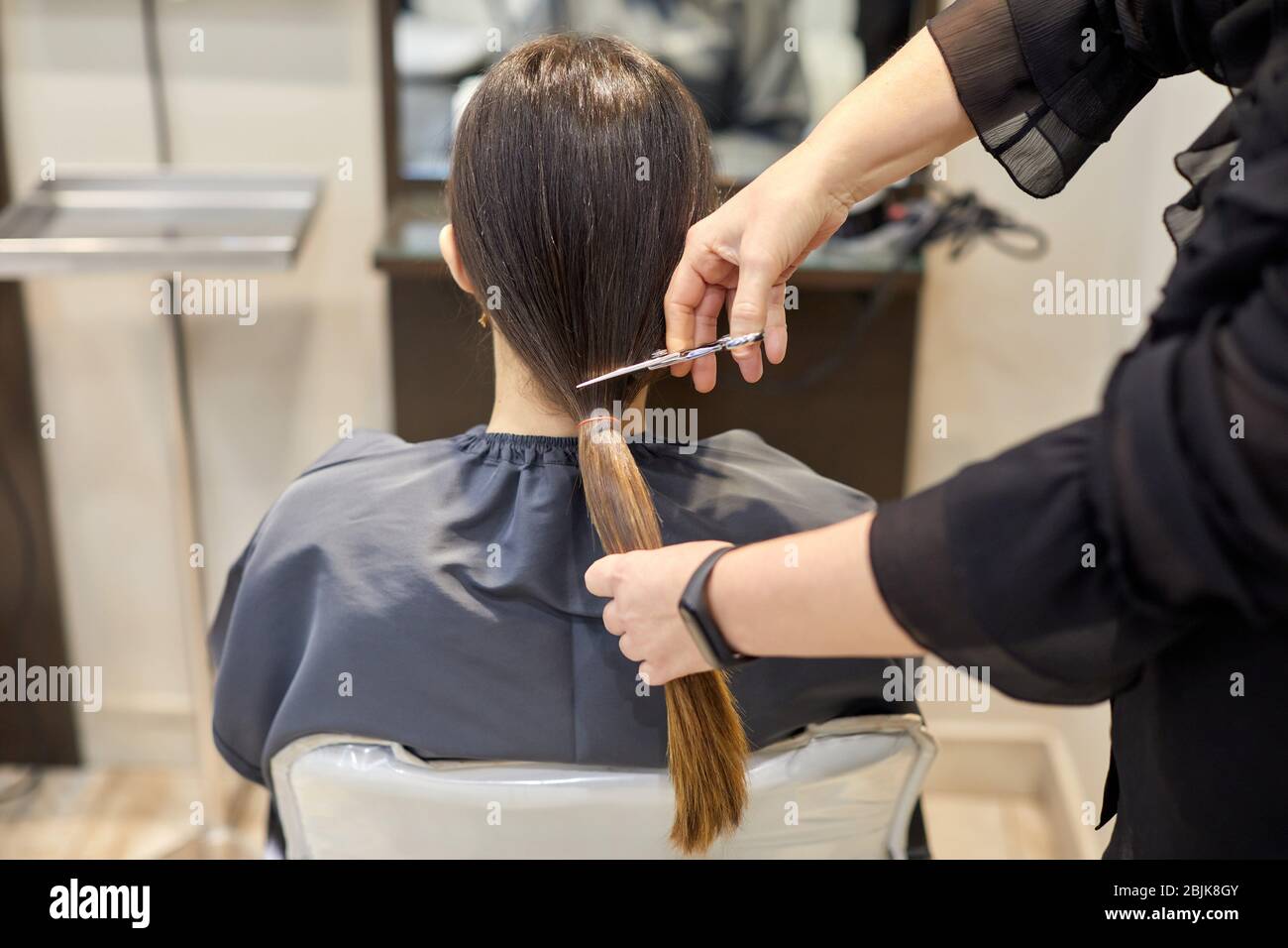 Friseur Schneiden einer Frau Haarschwanz, Haarspende-Programm, Friseursalon und Beauty Clinic. Stockfoto