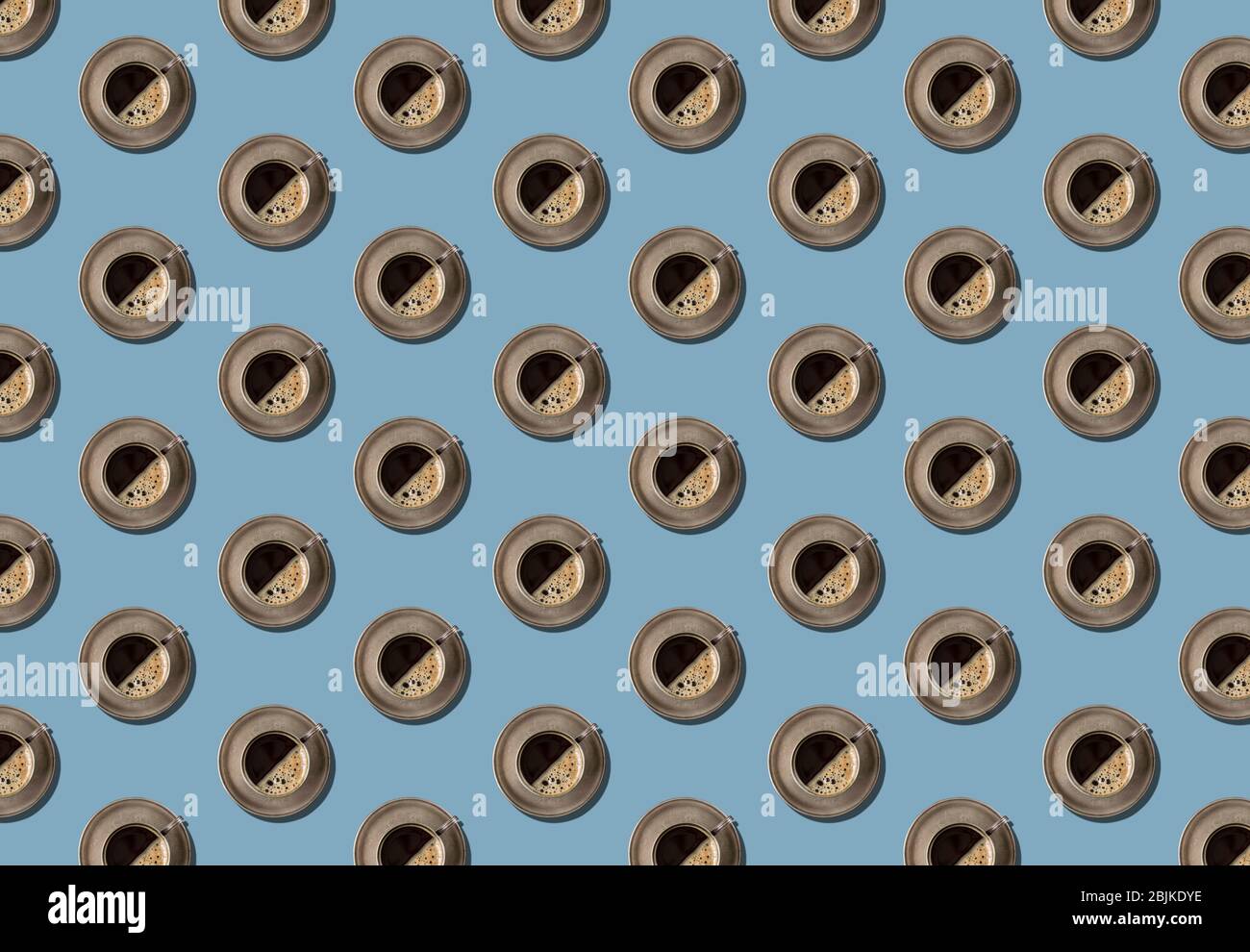 Nahtloses Muster aus Metall Kaffeetasse auf einem klassischen blauen Hintergrund. Cupronickel Kaffee paar mit schwarzem Kaffee. Minimales Konzept Stockfoto