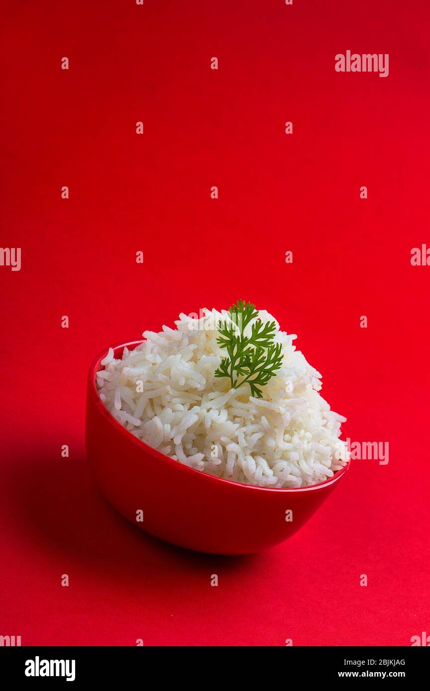 Gekochter weißer Basmati-Reis in einer roten Schüssel auf rotem ...
