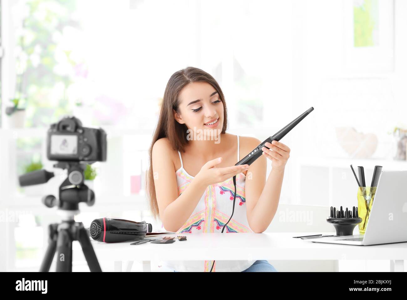 Junge Bloggerin mit Eisenkerne, die zu Hause Video aufzeichnet Stockfoto