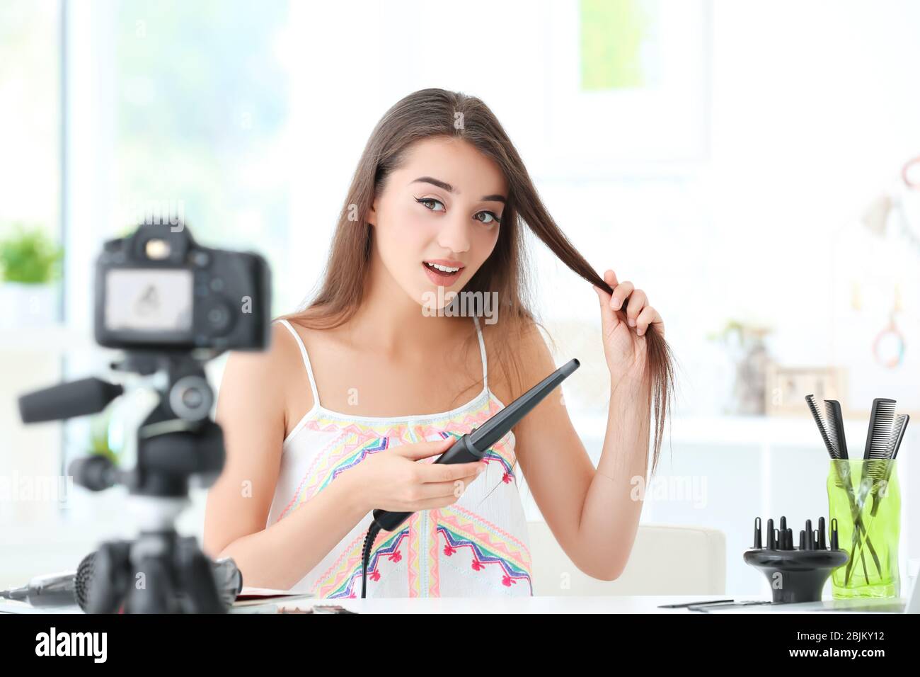 Junge Bloggerin mit Eisenkerne, die zu Hause Video aufzeichnet Stockfoto