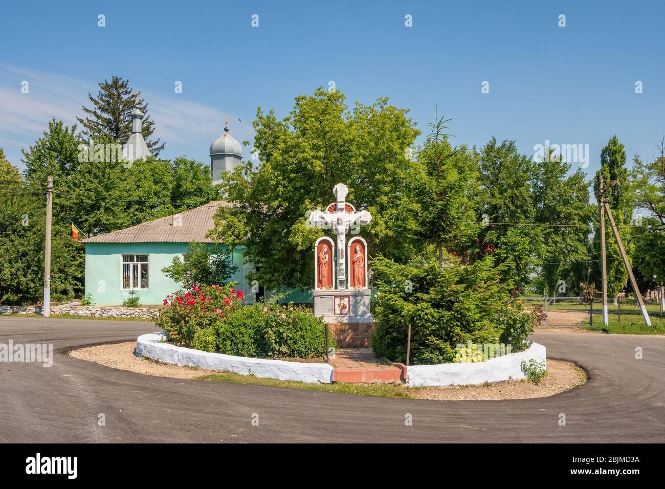 Orthodoxes christliches Kreuz und kleine Kirche in einem kleinen Dorf in Moldawien. Ländliche Sommerlandschaft aus Moldawien Stockfoto