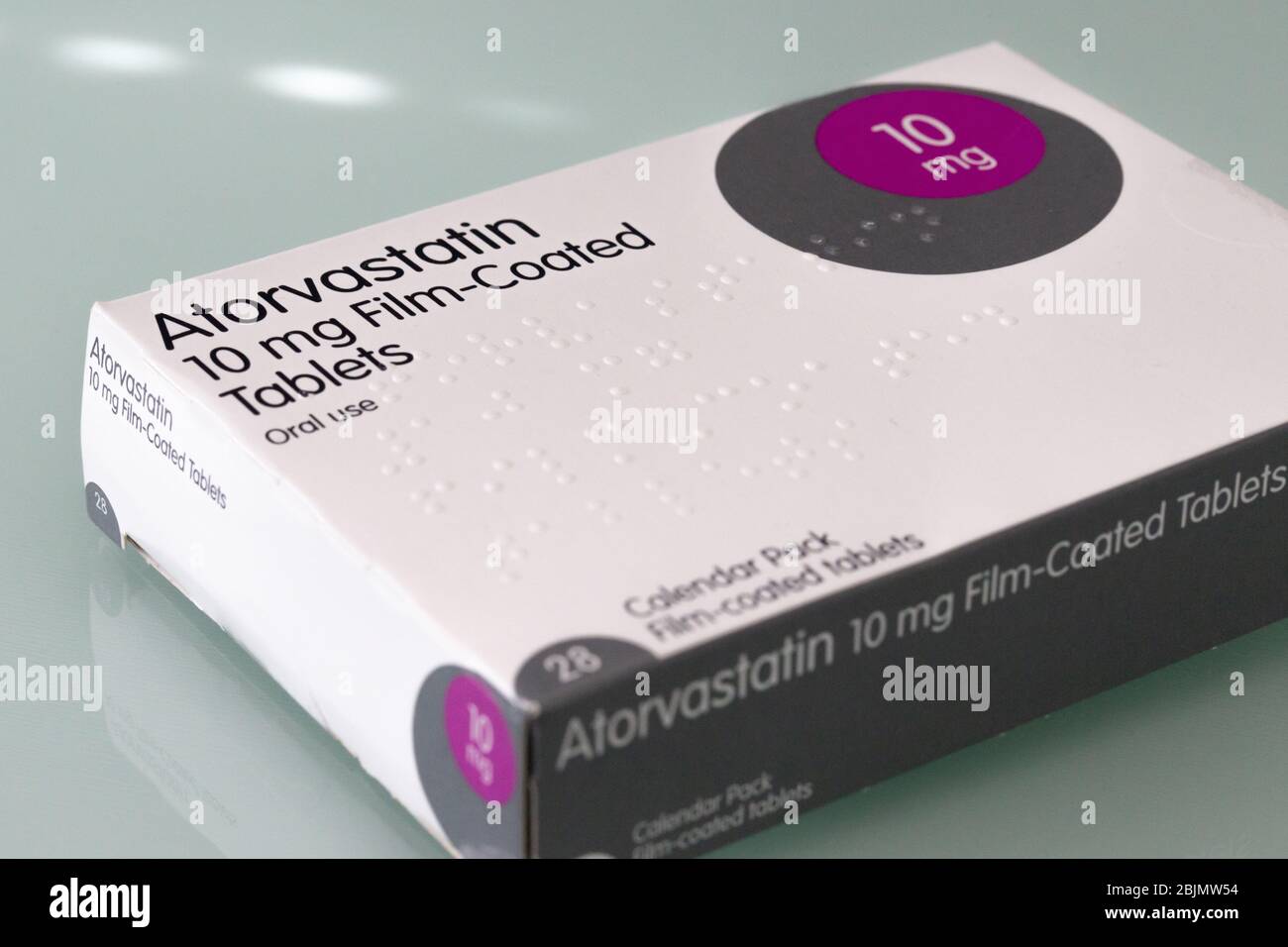 Eine Schachtel Tabletten mit Atorvastatin auf einem Glastisch Stockfoto
