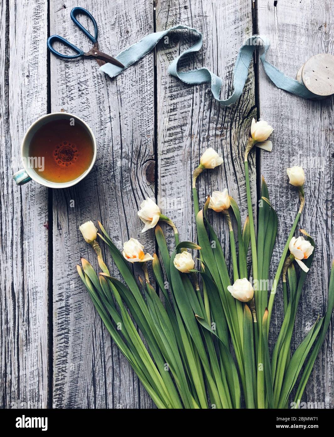 Tasse Tee und ein Bouquet von Narzissen Stockfoto