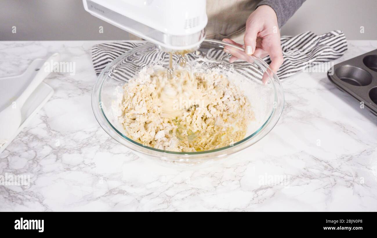 Schritt für Schritt. Mischen von Zutaten in einer Mischschale zum Backen von Preiselbeer-Muffins. Stockfoto