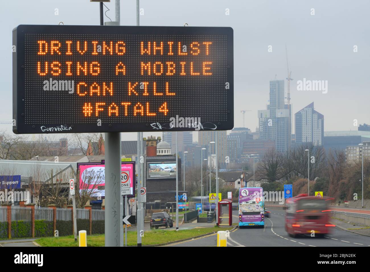 Verkehr Passieren Waring Zeichen der Verwendung von Mobiltelefonen während der Fahrt, leeds uk, die tödliche 4 - Beschleunigung, Handys, Sicherheitsgurte und Getränke / Fahren. Stockfoto