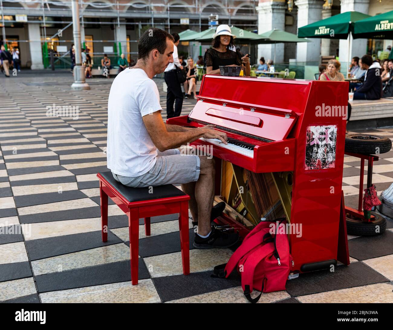 Mann, der ein rotes Klavier spielt, Place Massena, Nizza, Cote d'Azur, Provence, Frankreich. Stockfoto