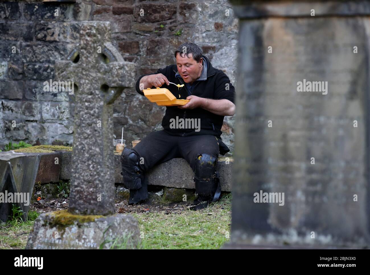 Ein Benutzer (Name nicht gegeben) des Dienstes angeboten durch die Step to Hope Wohltätigkeitsorganisation isst sein Essen auf dem Gelände der Pfarrkirche St. Cuthbert in Edinburgh. Die Wohltätigkeitsorganisation in Edinburgh, die Mahlzeiten an Obdachlose verteilt, normalerweise werden Mahlzeiten in der Kirche serviert, aber aufgrund von Einschränkungen werden diese außerhalb an Obdachlose übergeben, da das Vereinigte Königreich weiterhin in der Sperre bleibt, um die Ausbreitung des Coronavirus einzudämmen. Stockfoto