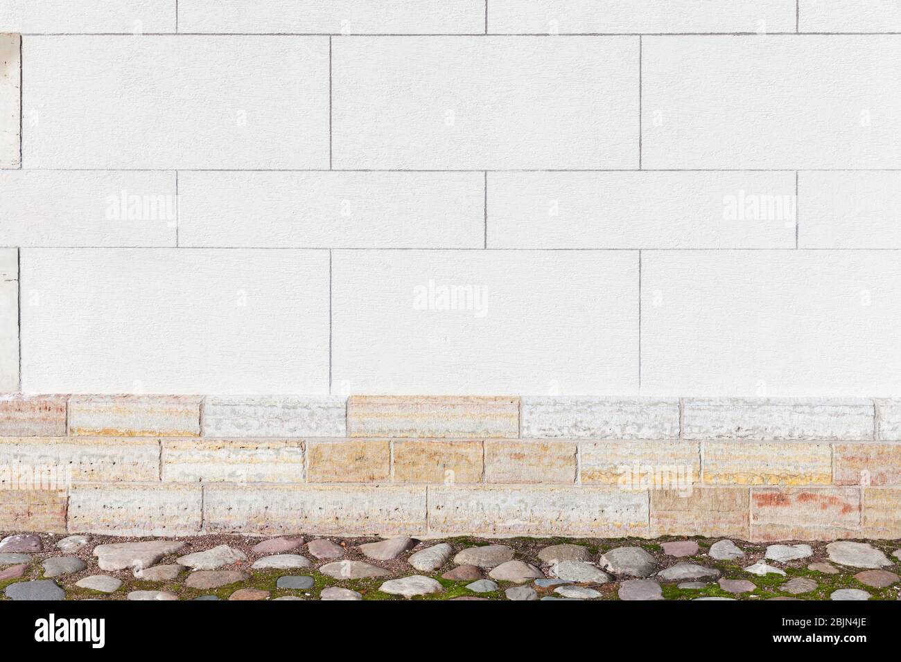 Weiße Steinwand mit Kopfsteinpflaster Boden, eine leere städtische Innenraum, Hintergrund Foto Textur Stockfoto