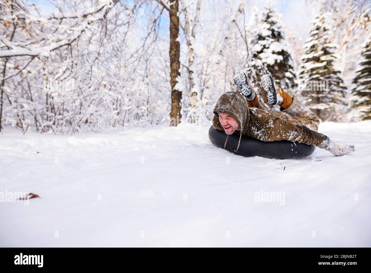 Mann tubing einen Hügel im Schnee, USA Stockfoto
