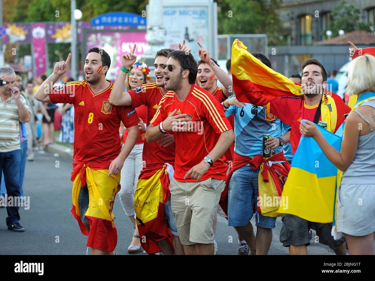 Betrunkene spanische Fußballfans tragen ein rotes T-Shirt, Gesichter in Nationalfarben bemalt und jubeln auf der Straße für seine Fußballmannschaft Stockfoto