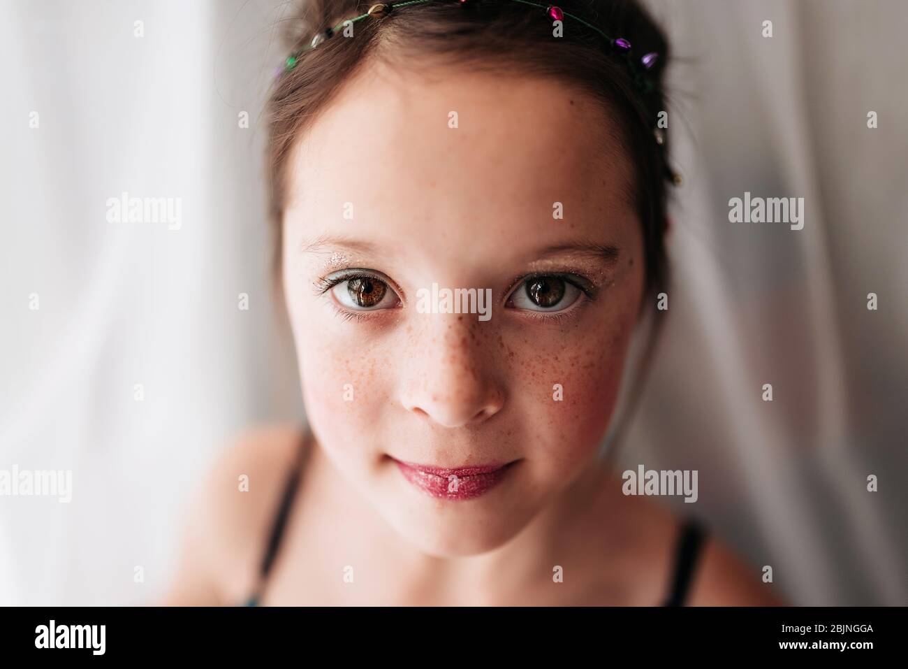 Porträt eines jungen Mädchens mit Make-up, das an einem Vorhang steht Stockfoto
