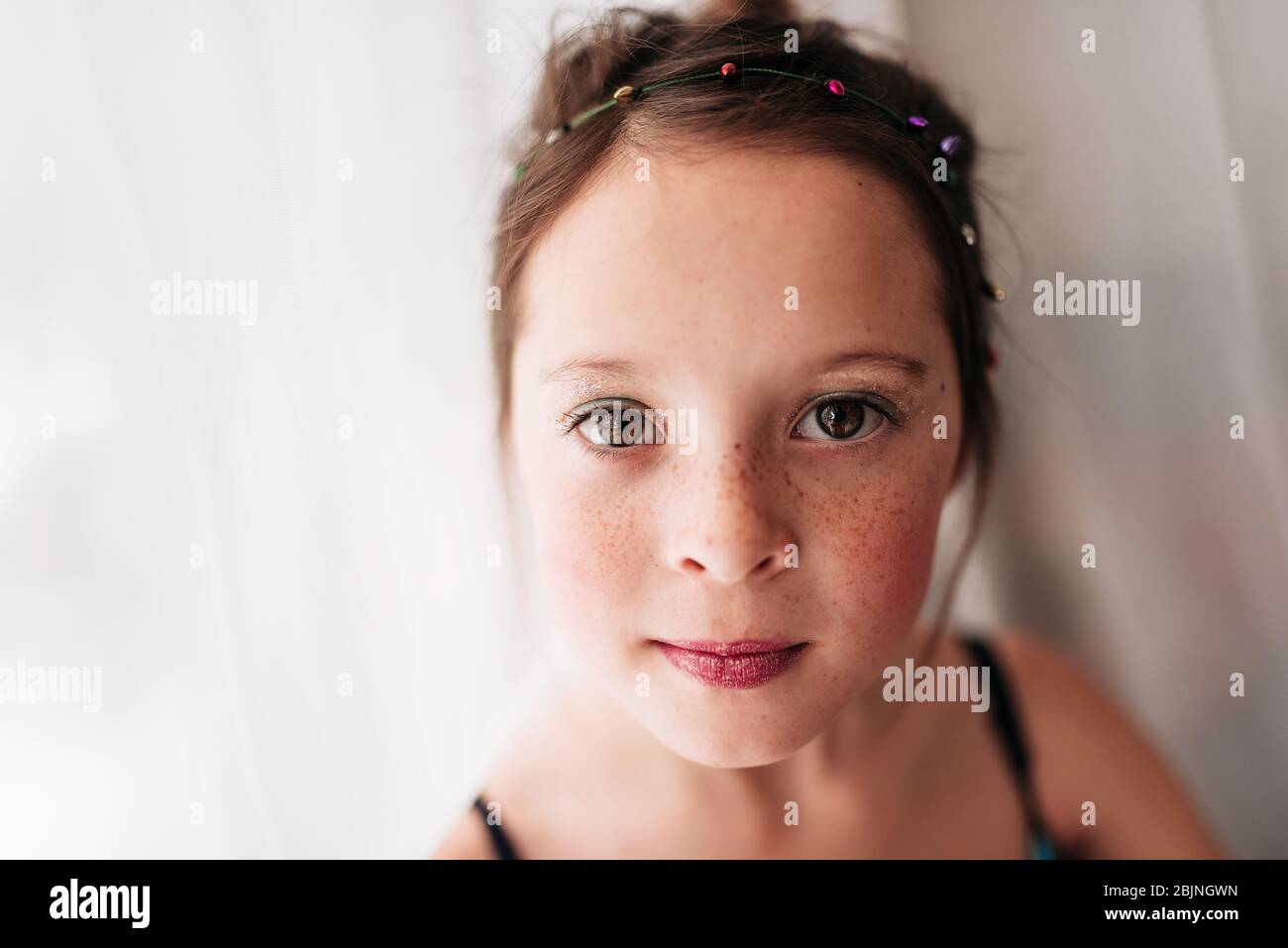 Porträt eines jungen Mädchens mit Make-up, das an einem Vorhang steht Stockfoto