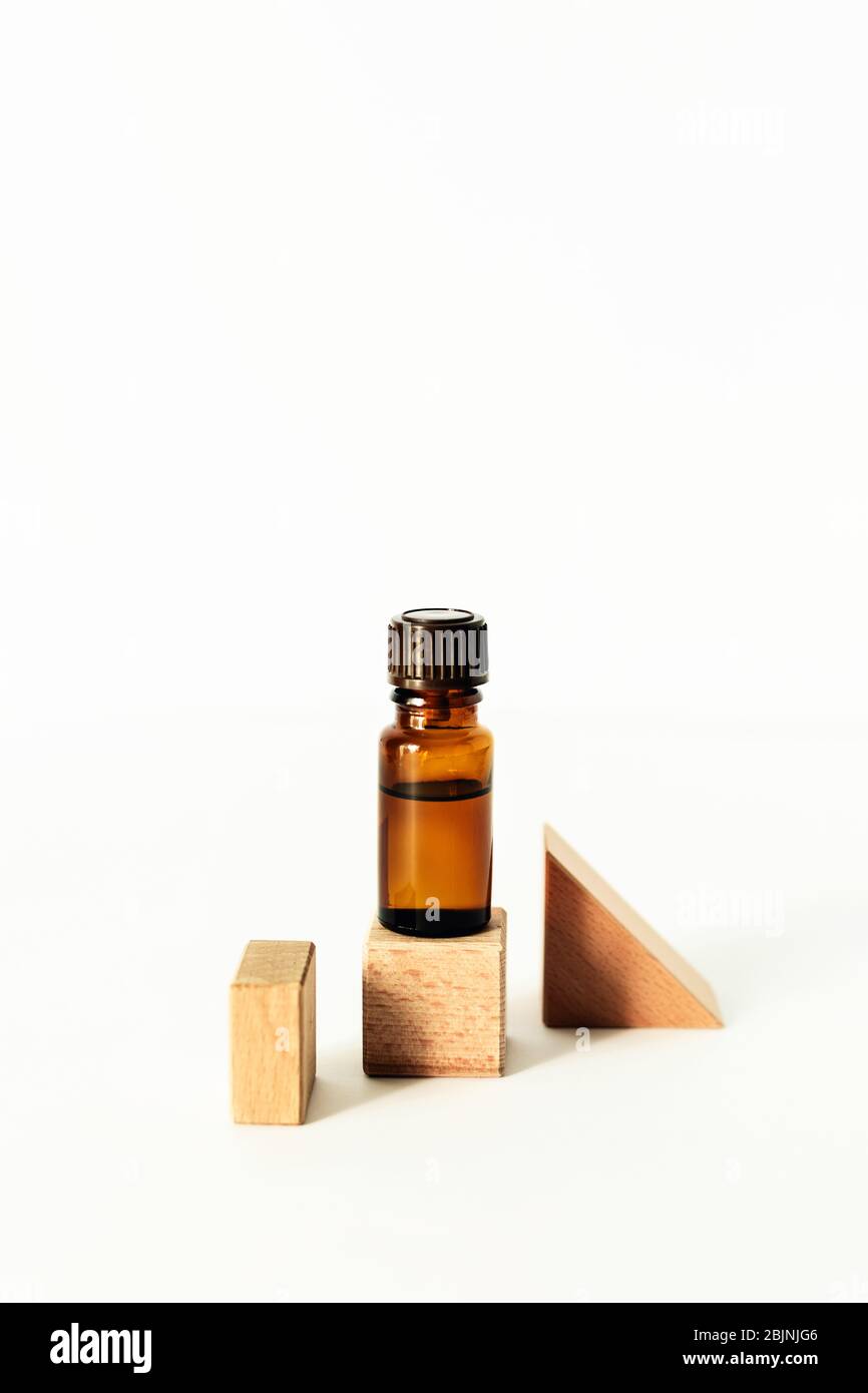 Flasche mit aromatischem Öl auf einem Holzwürfel. Vorderansicht. Stockfoto