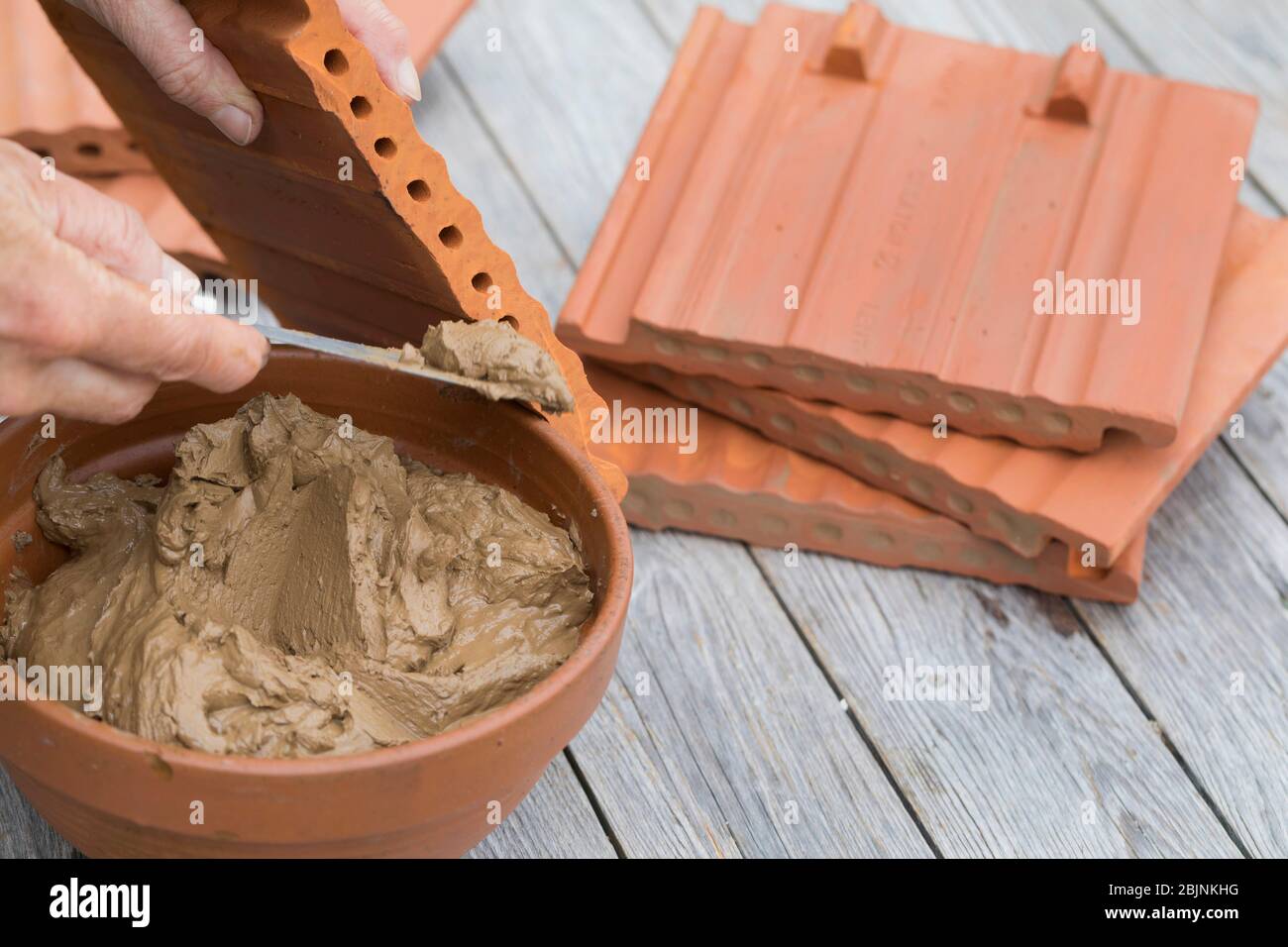 Nisthilfe für Wildbienen, ineinander greifende Pantile, Schritt 3: Auf der einen Seite die Löcher mit Lehm verschlossen, Deutschland Stockfoto