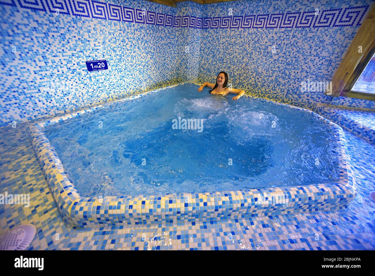 Junge Frau in einem Whirl-Pool, Frankreich, Savoie, Sainte-Foy-Tarentaise Stockfoto