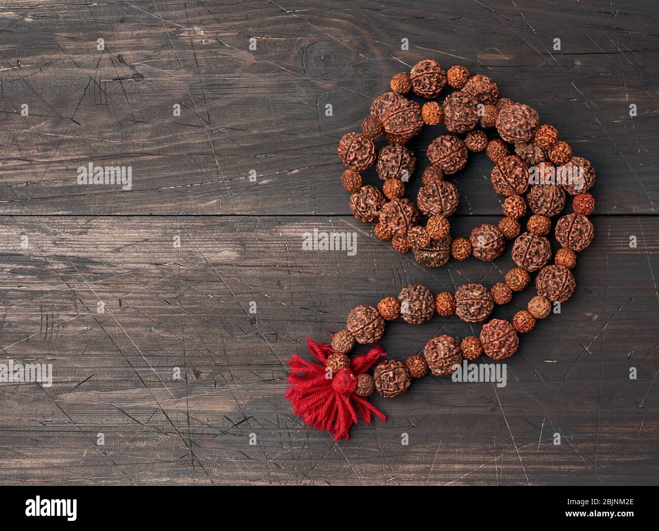 Rudraksha Gebetsperlen für Meditation auf einem braunen Holzhintergrund, Draufsicht. Japa mala, Kopierraum Stockfoto