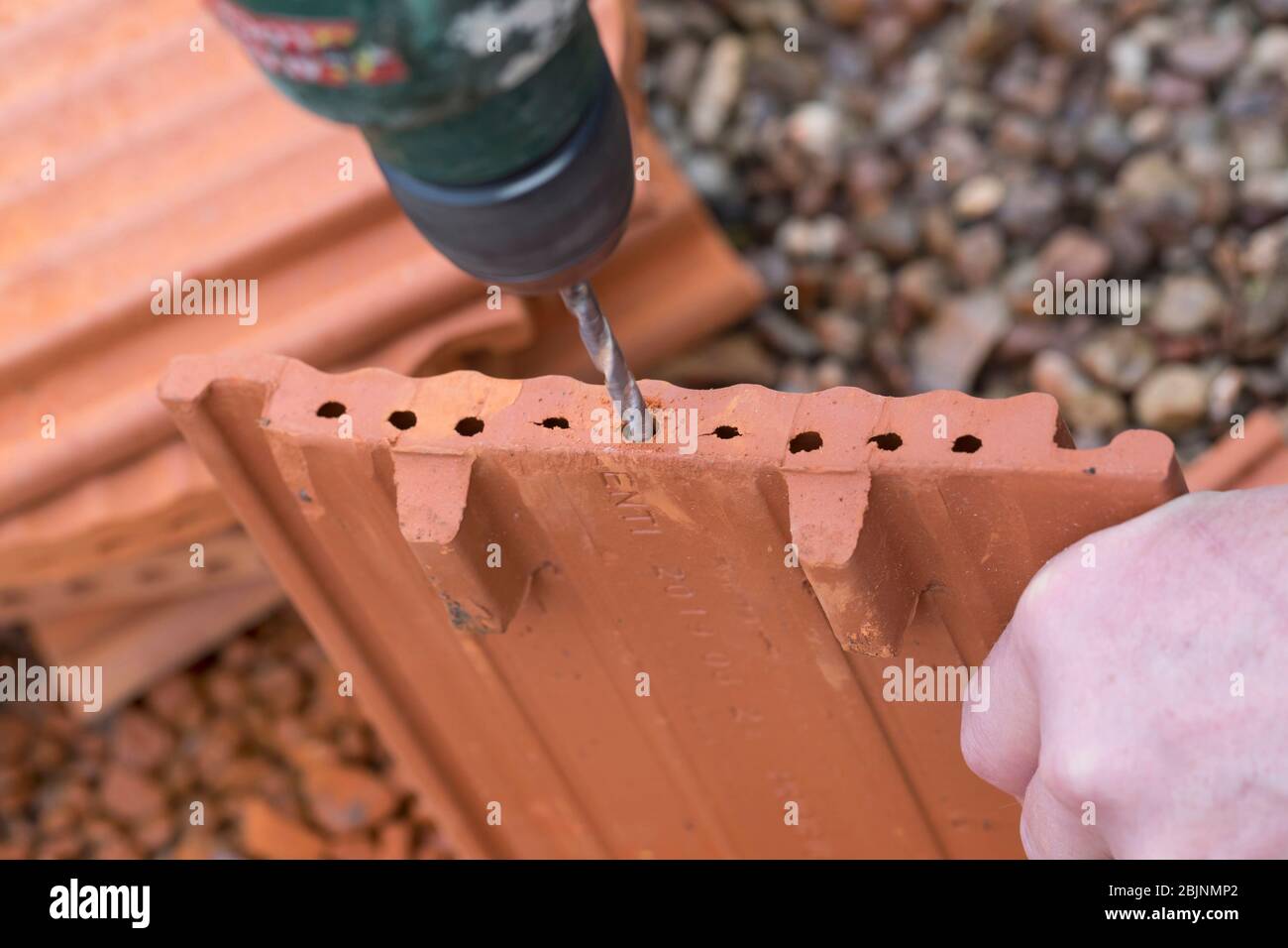 Nisthilfe für Wildbienen, ineinander greifende Pantile, Schritt 2: Lochrand glätten durch einen Bohrer, Deutschland Stockfoto