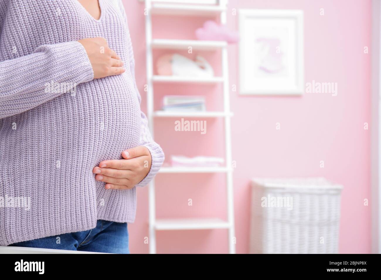 Schwangere Frau im Zimmer des Babys Stockfoto