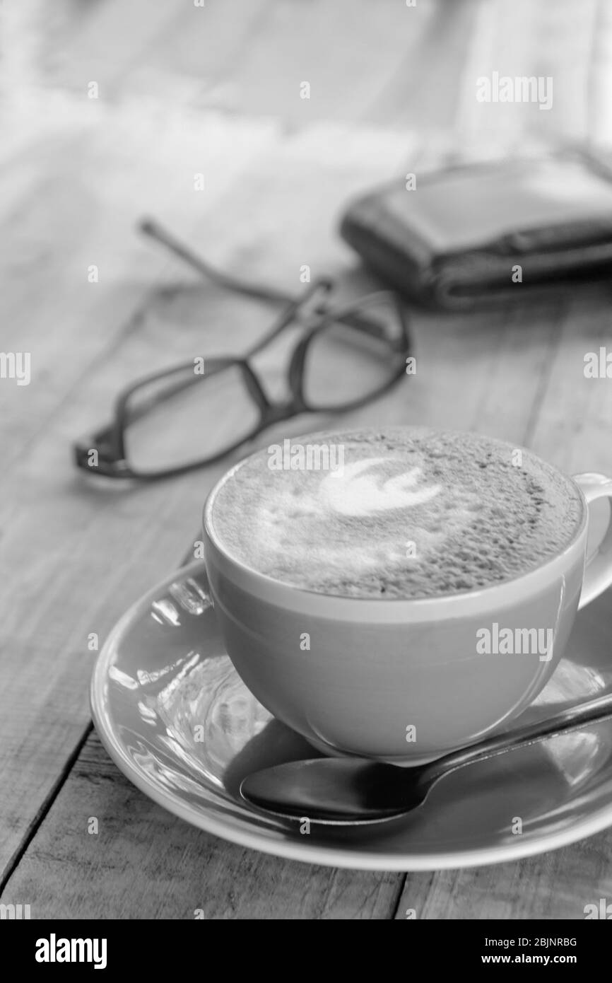 Orange Tasse Kaffee latte Art mit Blatt Muster auf Holz- hintergrund, in der Nähe der Kunst Kaffee am Morgen Stockfoto
