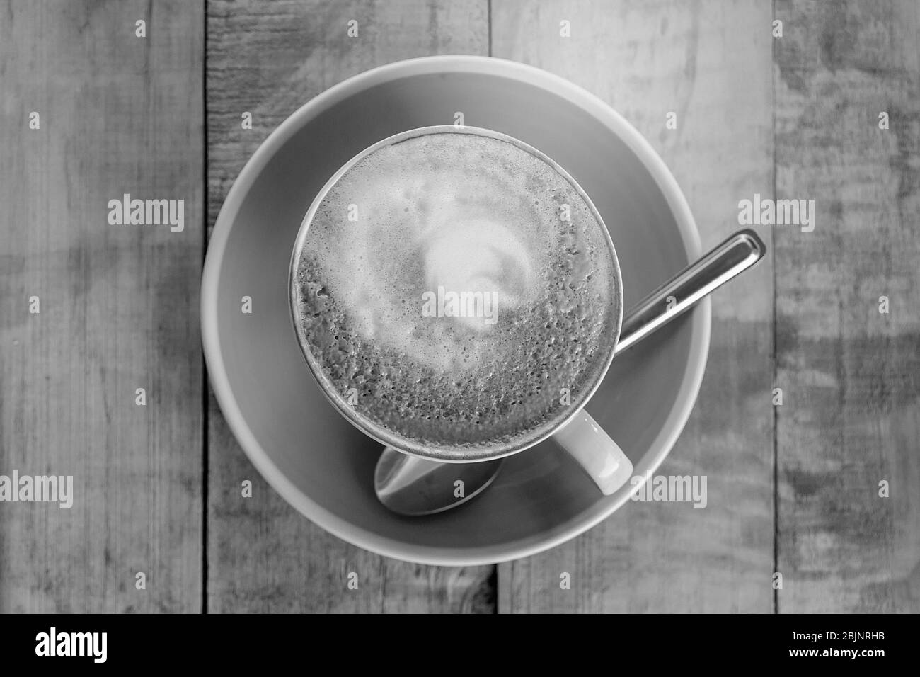Orange Tasse Kaffee latte Art mit Blatt Muster auf Holz- hintergrund, in der Nähe der Kunst Kaffee am Morgen Stockfoto