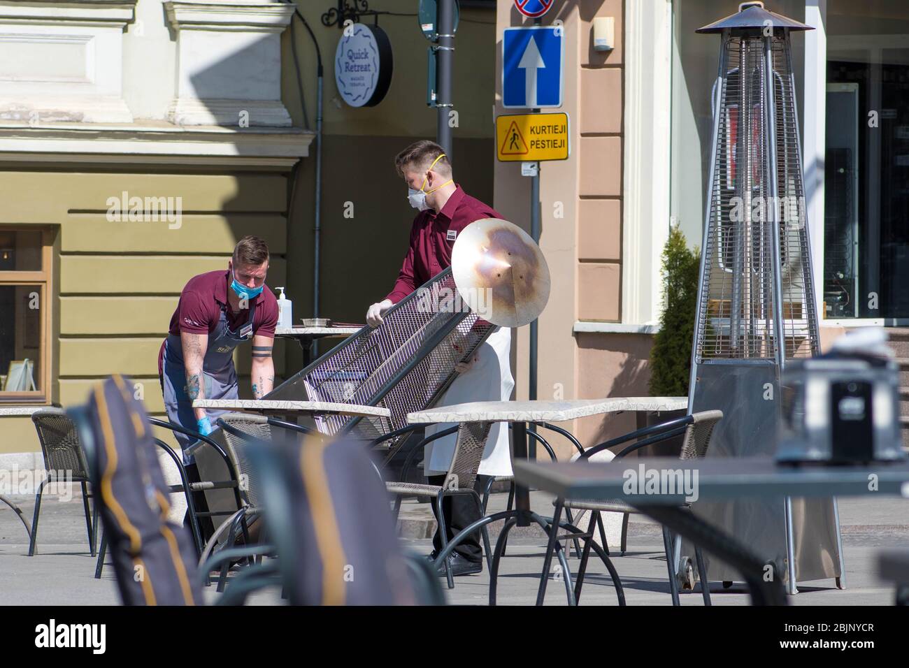 Kellner mit Maske öffnen nach Quarantäne-Einschränkungen eine Bar, ein Café oder ein Restaurant im Freien Stockfoto