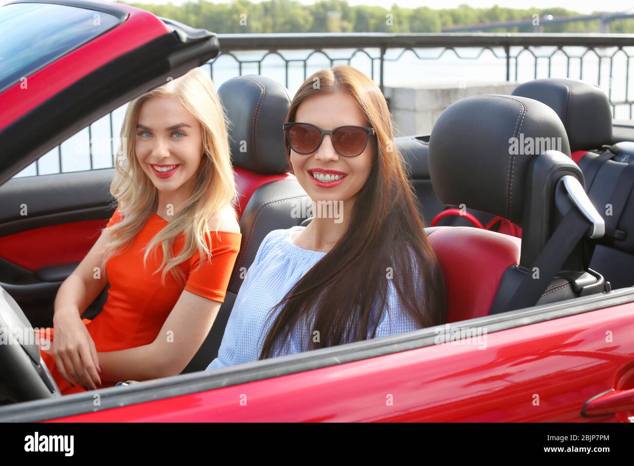 Zwei schöne junge Frauen im Cabrio draußen Stockfoto