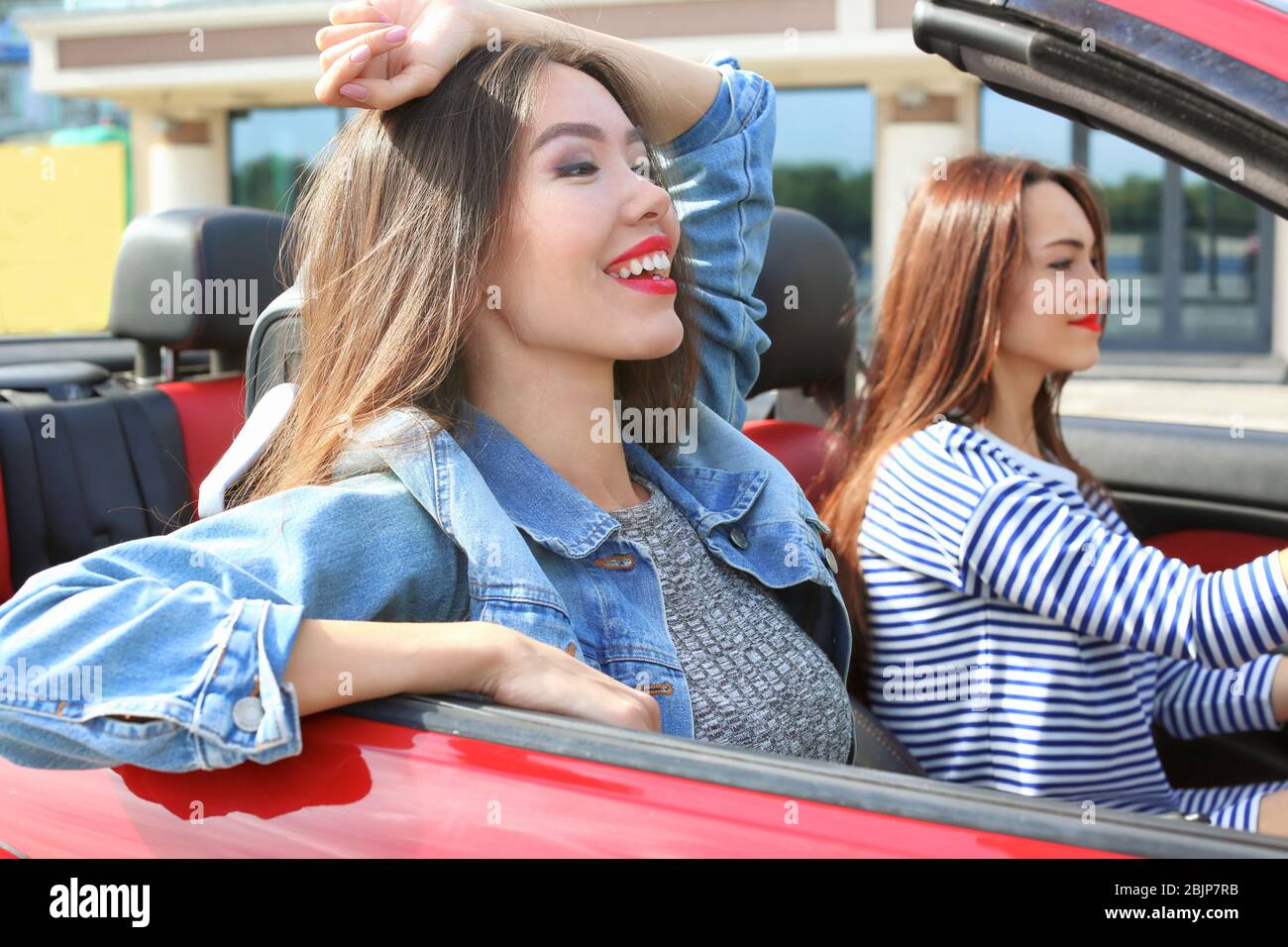 Zwei schöne junge Frauen im Cabrio draußen Stockfoto